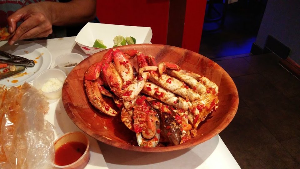 Menu board showing seafood boils, sides, and soft drinks.